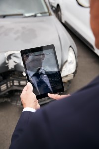 mężczyzna robi zdjęcia uszkodzonego pojazdu